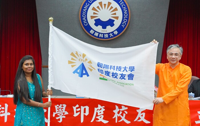 President Cheng Tao-Ming (right) put on the traditional costume gifted from Keerthika (left) and presented the branch flag to her.